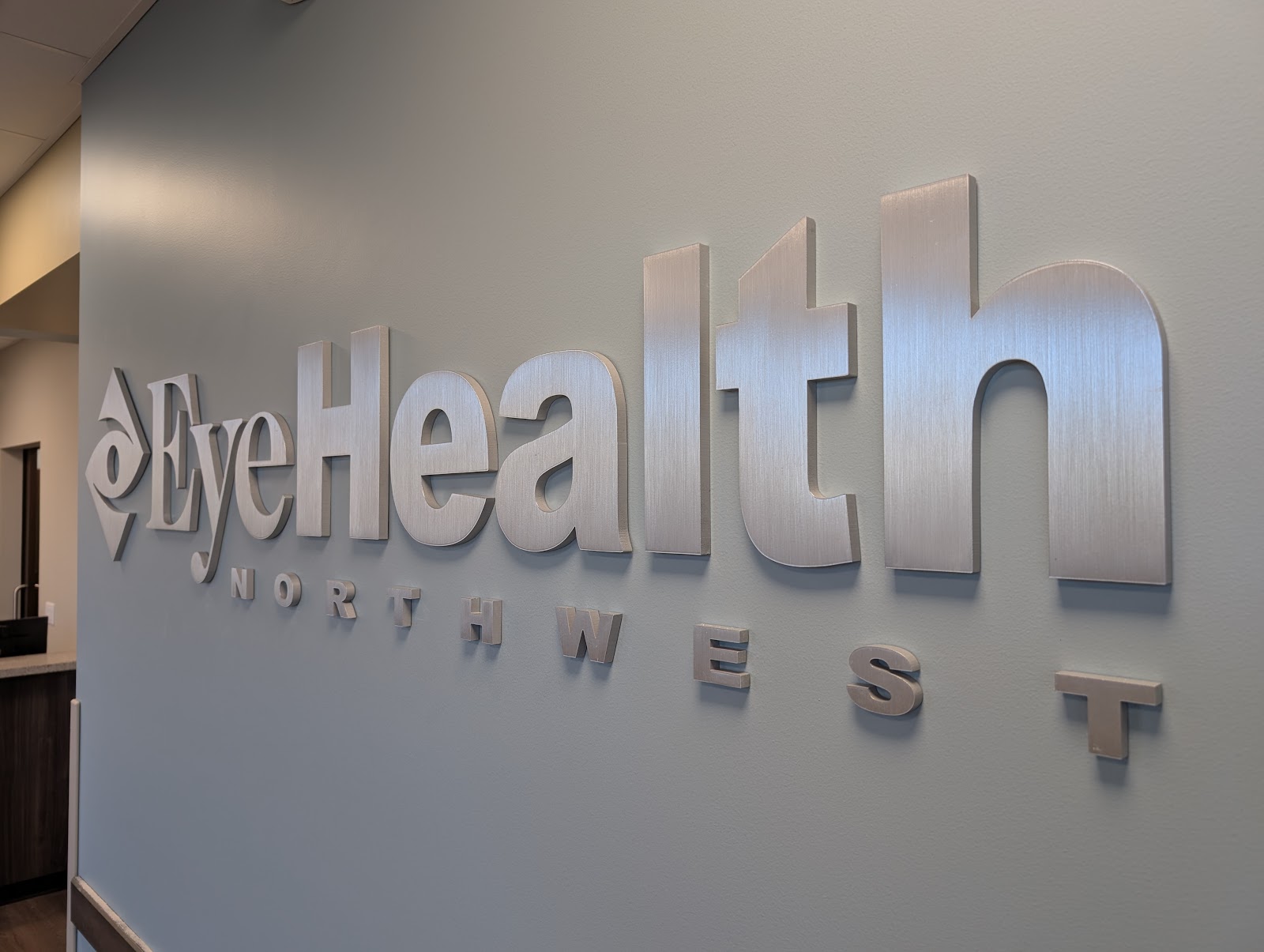 Brushed metal dimensional lobby sign with logo and text in Portland, OR.