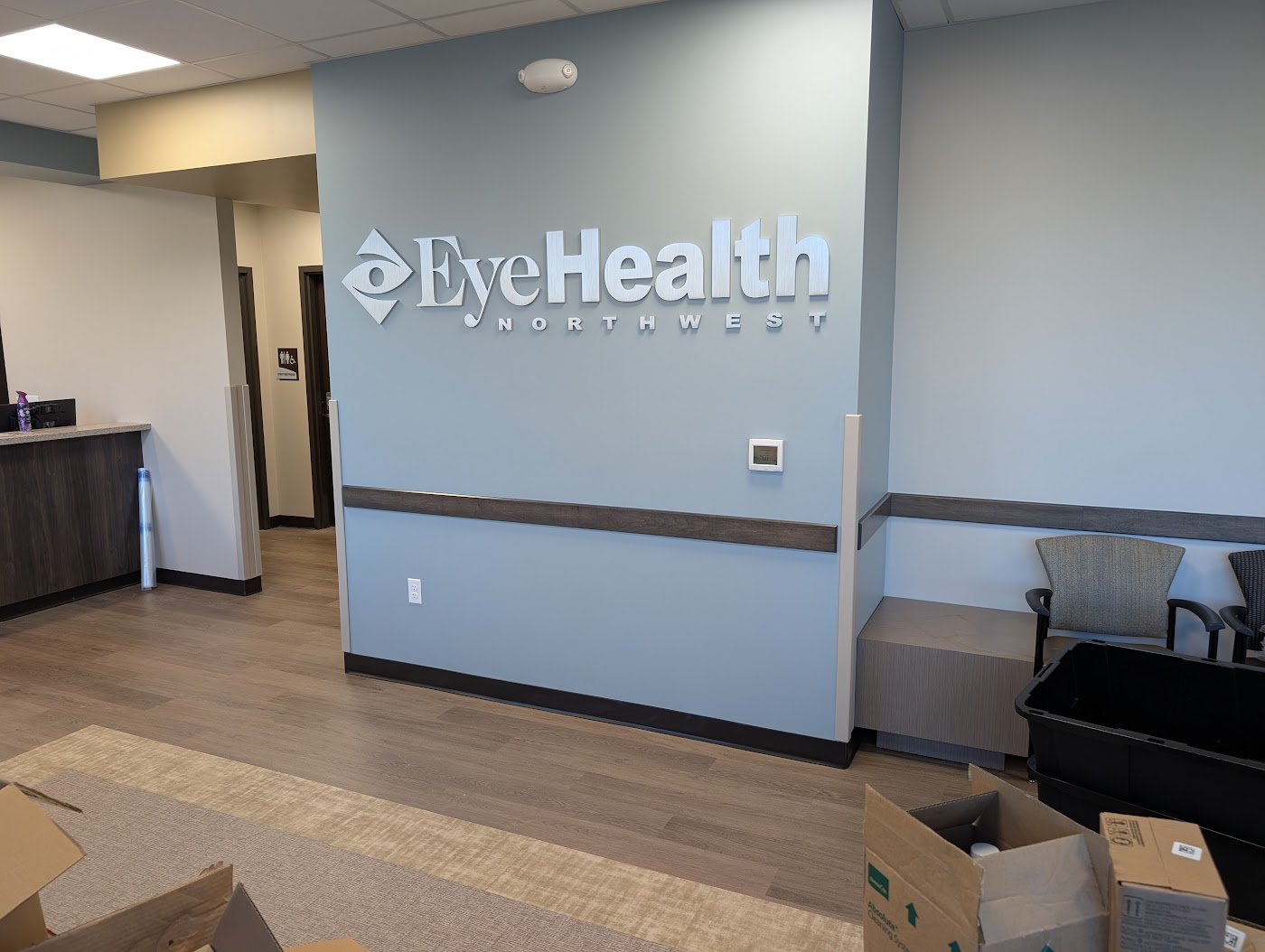 Dimensional metal lobby sign with logo and letters on a blue wall in Portland, OR.